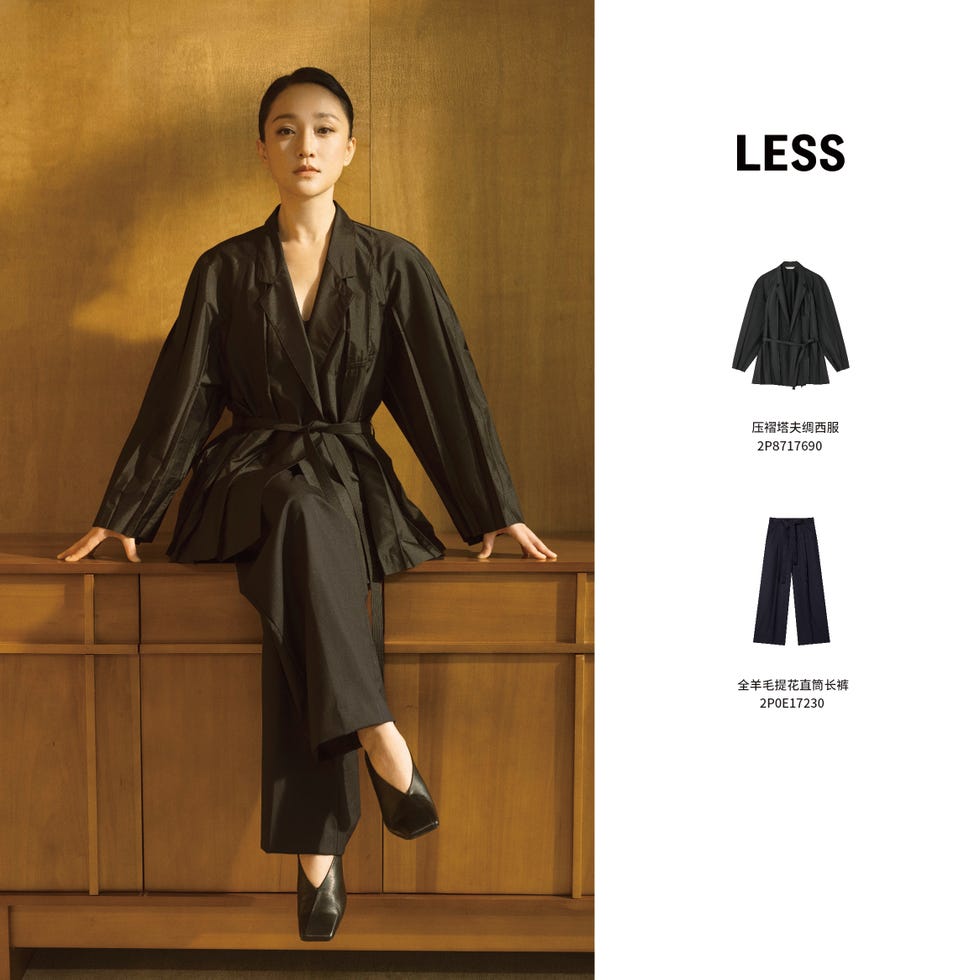fashion model displaying contemporary black clothing against a wooden background