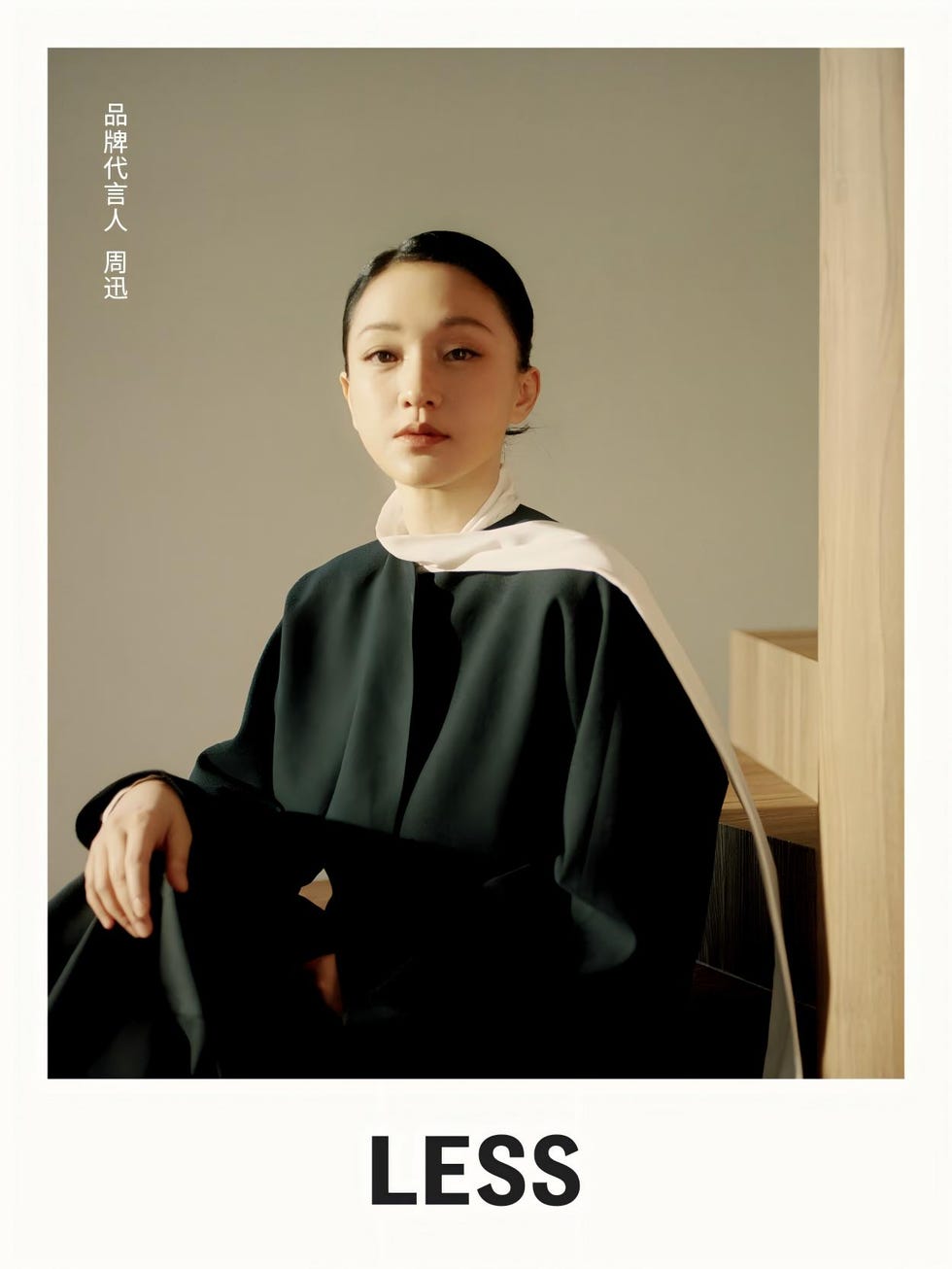 a person seated in a minimalist fashion outfit with a prominent text overlay