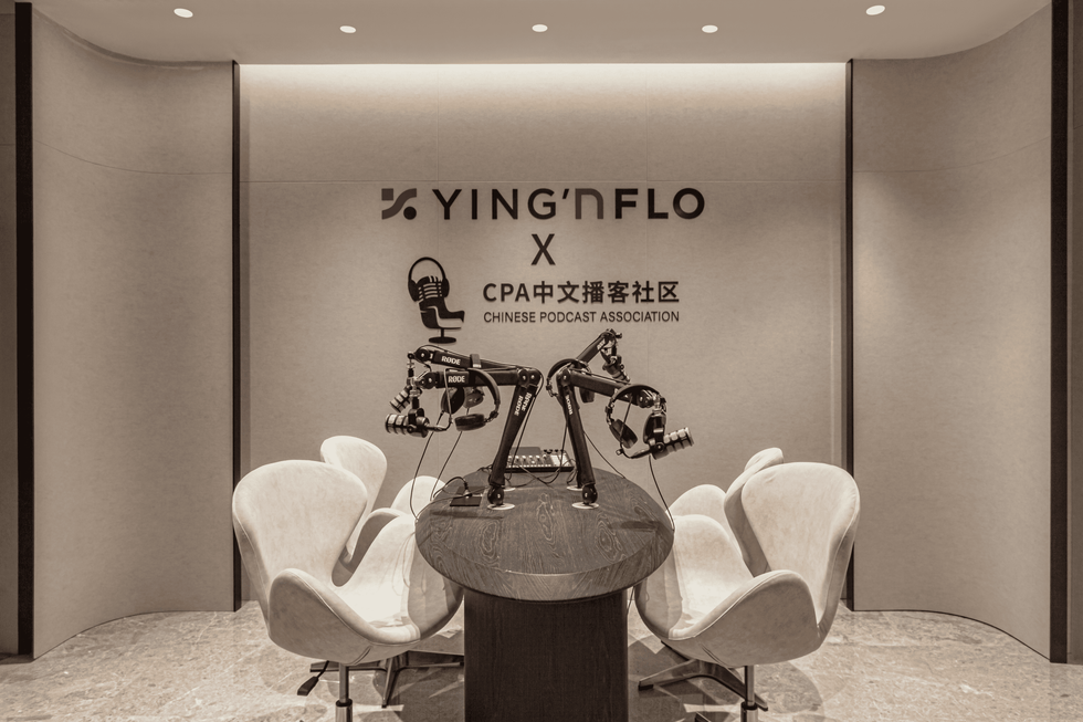 podcasting setup featuring microphones and seating area branded with yingnflo and chinese podcast association