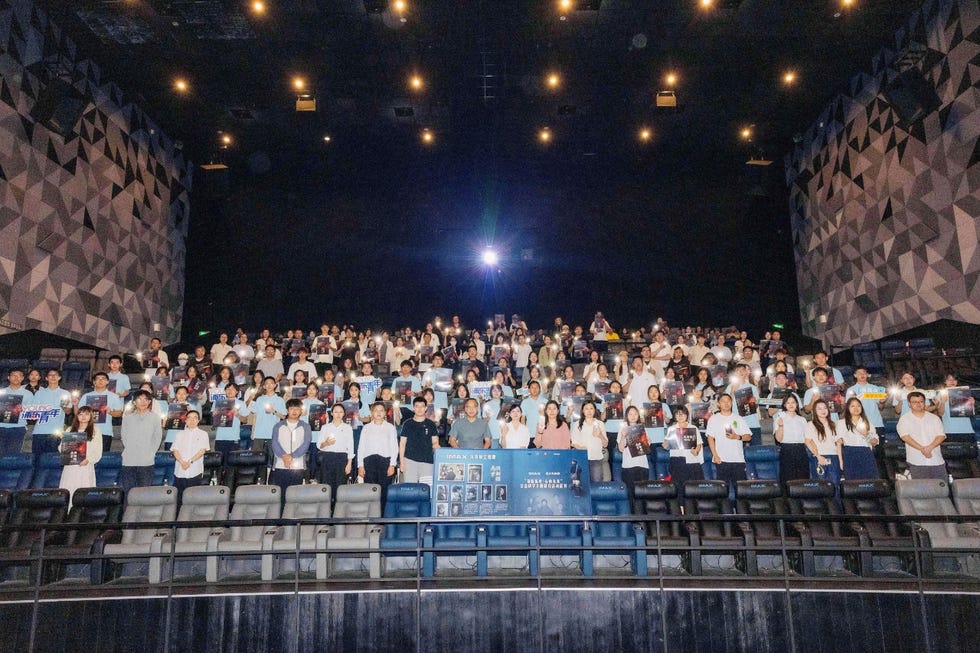 audience in a theater holding promotional materials for an event